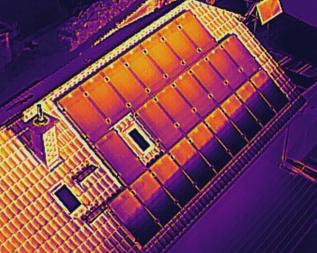 Thermografische Drohnenaufnahme einer Photovoltaikanlage auf einem Dach